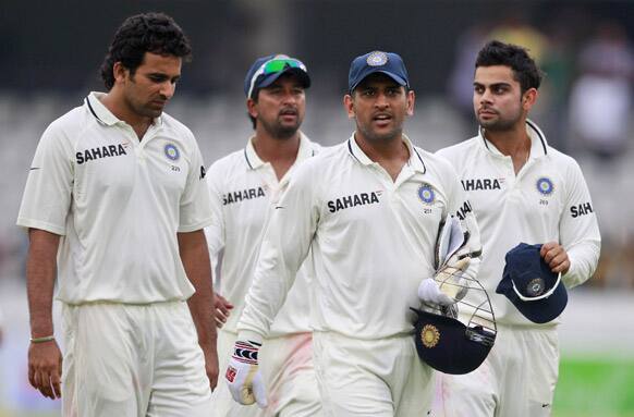 Mahendra Singh Dhoni, walks with teammates Virat Kohli, Zaheer Khan, and Pragyan Ojha at the end of the second day of the first cricket test match against New Zealand in Hyderabad.