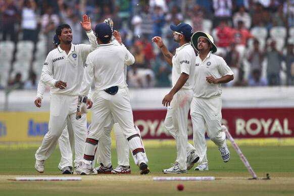 Pragyan Ojha celebrates with teammates the dismissal of New Zealand cricketer Doug Bracewell during their third day of the first cricket test match in Hyderabad.