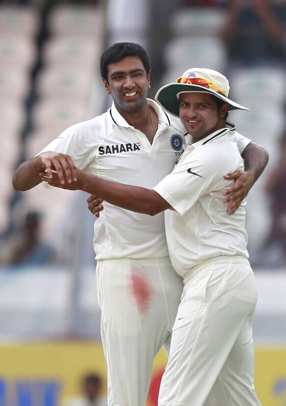 Ravichandran Ashwin celebrates with teammate Suresh Raina after taking the wicket of New Zealand batsman Trent Boult during their third day of the first cricket test match in Hyderabad.