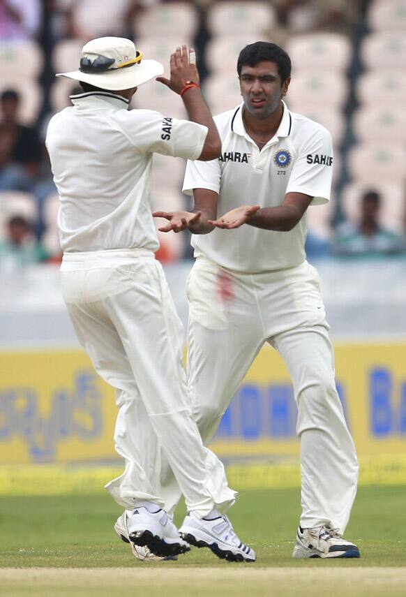 Ravichandran Ashwin celebrates with a teammate after taking the wicket of New Zealand batsman Jeetan Patel during their third day of the first cricket test match in Hyderabad.