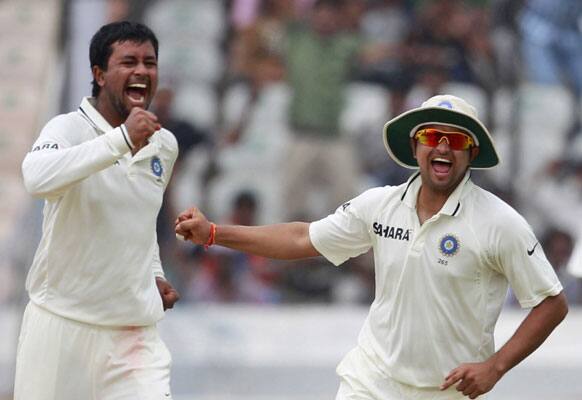 Pragyan Ojha, celebrates with teammate Suresh Raina the dismissal of New Zealand cricketer Martin Guptill during the third day of the first cricket test match in Hyderabad.