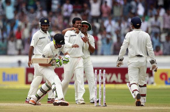 Pragyan Ojha, celebrates with Suresh Raina, the dismissal of New Zealand cricketer Martin Guptill, holding bat, during the third day of the first cricket test match in Hyderabad.