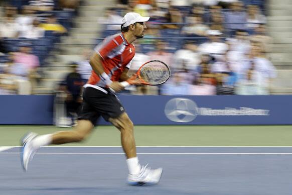 Ivan Dodig, of Croatia, runs to the net during a match against Andy Murray, of Britain, at the US Open tennis tournament.