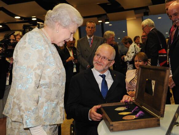 Britain's Queen Elizabeth II is presented with three Paralympic medals by Sir Philip Craven, President of the International Paralympic Committee at a reception at the Olympic Stadium ahead of the opening ceremony for the London Paralympic Games 2012, in London.