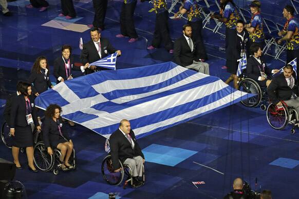 Greek team members carry their flag into the arena during the Opening Ceremony for the 2012 Paralympics in London.