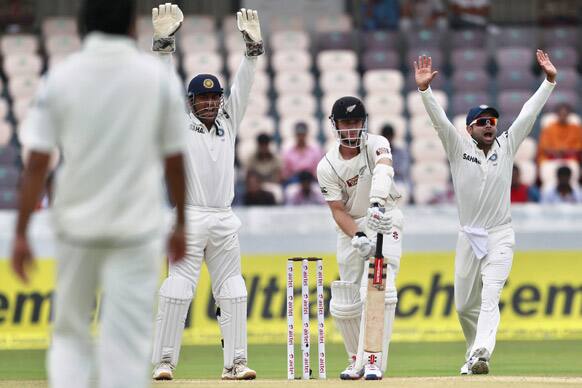 Mahendra Singh Dhoni and teammate Virat Kohli appeal unsuccessfully for the wicket of New Zealand's batsman Kane Williamson during the fourth day of their first cricket test match in Hyderabad.