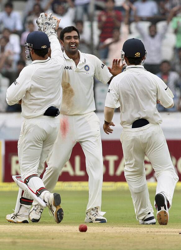 Ravichandran Ashwin celebrates with teammates the dismissal of New Zealand's captain Ross Taylor during the fourth day of their first cricket test match in Hyderabad.