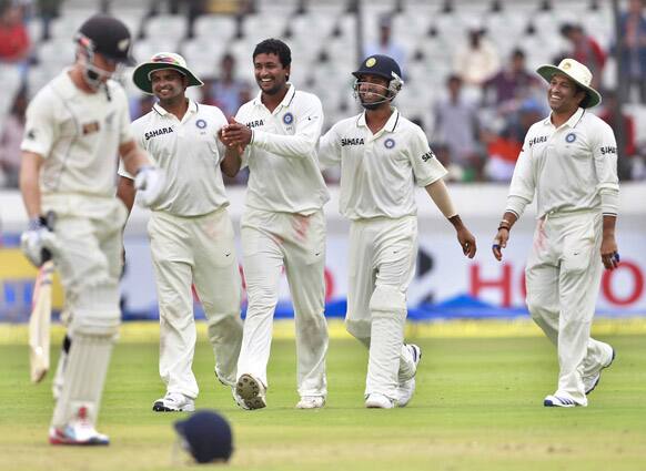 Pragyan Ojha celebrates with teammates the dismissal of New Zealand's batsman Kane Williamson during the fourth day of their first cricket test match in Hyderabad.