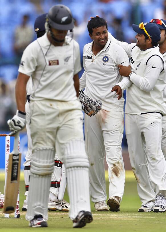 Pragyan Ojha celebrates with teammates the dismissal of New Zealand captain Ross Taylor during the first day of their second cricket test match in Bangalore.