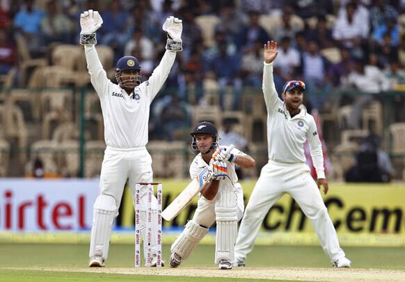 Mahendra Singh Dhoni and teammate Virat Kohli appeal unsuccessfully for the wicket of New Zealand batsman Kruger van Wyk during the first day of their second cricket test match in Bangalore.