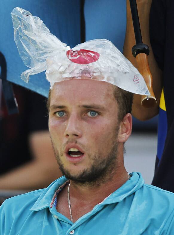 Belgium's Steve Darcis uses an ice bag to cool down during his match with Switzerland's Stanislas Wawrinka in the third round of play at the 2012 US Open tennis tournament, in New York.