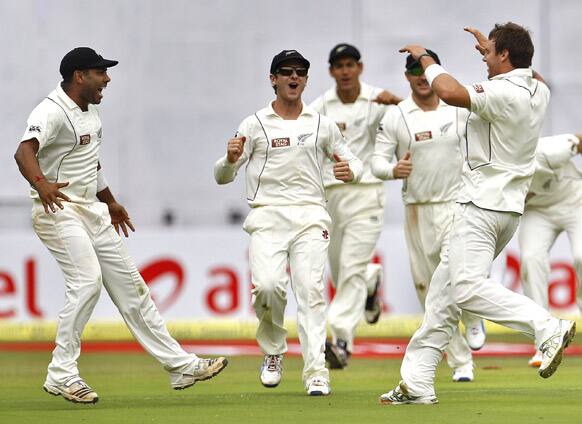 New Zealand bowler Doug Bracewell celebrates with teammates after taking the wicket of India's batsman Sachin Tendulkar during the second day of their second cricket test match in Bangalore.