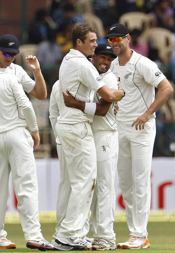 New Zealand bowler Tim Southee, third right, celebrates with teammates after taking the wicket of India's batsman Zaheer Khan, not seen, during the third day of their second cricket test match in Bangalore.