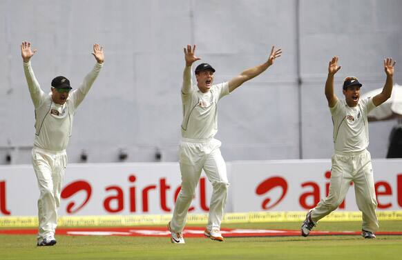 New Zealand captain Ross Taylor, right, and teammates Brendon McCullum, left, and Martin Guptill appeal successfully for the wicket of India's batsman Virat Kohli, not seen, during the third day of their second cricket test match in Bangalore.