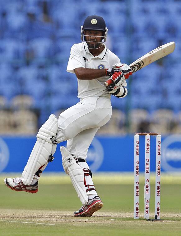 Cheteshwar Pujara watches his shot during the fourth day of their second cricket test match against New Zealand in Bangalore.