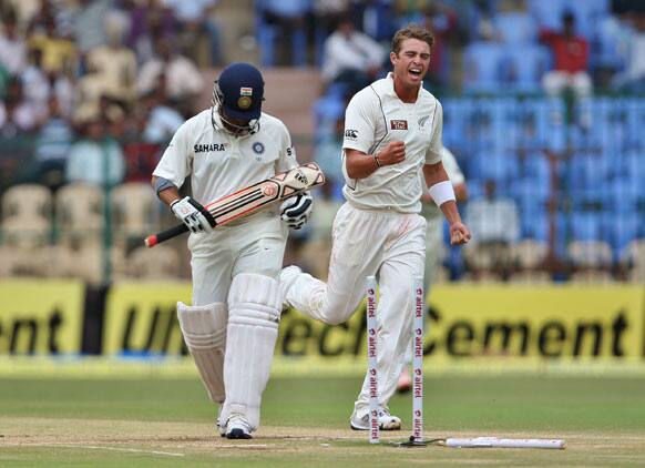 New Zealand bowler Tim Southee, right, celebrates after taking the wicket of India's batsman Sachin Tendulkar, left, during the fourth day of their second cricket test match in Bangalore.