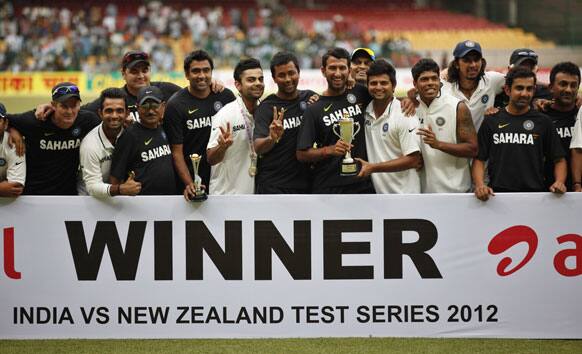 Members and the support staff of Indian cricket team pose with the winners trophy after their win over New Zealand on the fourth day of their second cricket test match in Bangalore.