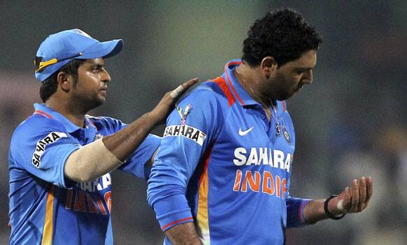 Indian cricketer Yuvraj Singh reacts after injuring his finger, as teammate Suresh Raina pats his back during the Twenty20 international cricket match between India and New Zealand in Chennai.