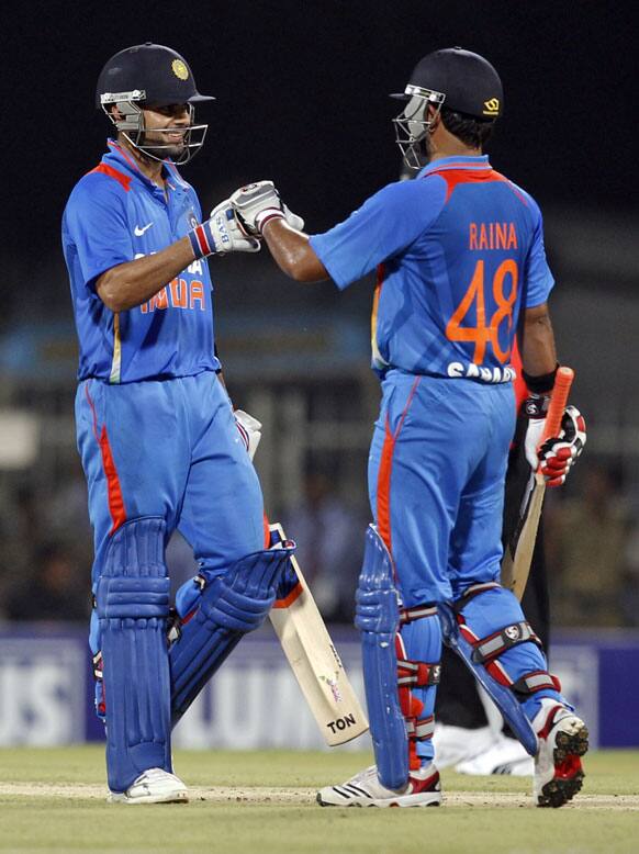 Indian cricketer Virat Kohli, lft, is congratulated by teammate Suresh Raina for scoring fifty runs during the second and final Twenty20 international cricket match between India and New Zealand in Chennai.