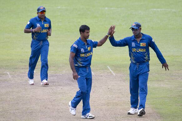 Sri Lanka's bowler Nuwan Kulasekara, center, celebrates the dismissal of India's batsman Virender Sehwag , unseen, with Angelo Mathews, right, and Rangana Herath, left, during a practice match between Sri Lanka and India ahead of the ICC T20 cricket World Cup in Colombo.