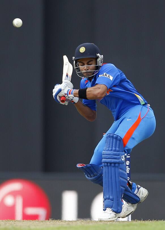 Virat Kohli bends to avoid a rising delivery from Pakistan's bowler Mohammad Sami, not seen, during their warm-up match ahead of the ICC Twenty20 Cricket World Cup in Colombo.