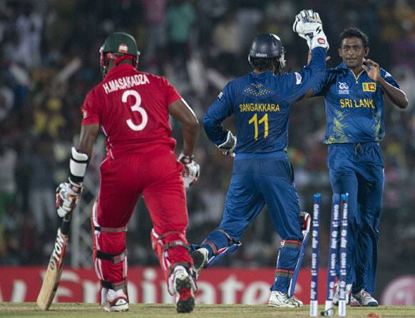 Sri Lanka's bowler Ajantha Mendis, right celebrates dismissal of Zimbabwe's Hamilton Masakadza, left with wicket keeper Kumar Sangakkara , center during the ICC Twenty20 Cricket World Cup match between Sri Lanka and Zimbabwe in Hambantota.