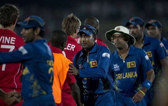 Sri Lanka's cricketers from left, Tillakaratne Dilshan, captain Mahela Jayawardena, and Lasith Malinga, shake hands with Zimbabwe's cricketers after Sri Lanka beat Zimbabwe by 82 runs during the ICC Twenty20 Cricket World Cup match between Sri Lanka and Zimbabwe in Hambantota.