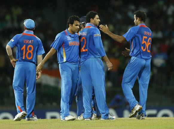 Members of the Indian team congratulate their bowler Yuvraj Singh, second right, for taking the wicket of Afghanistan's batsman Karim Sadiq, unseen, during their ICC Twenty20 Cricket World Cup match in Colombo.