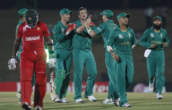 Albie Morkel, celebrates the dismissal of Zimbabwe's batsman Hamilton Masakadza, with captain AB de Villiers, Jean-Paul Duminy and Hashim Amla,  during the ICC Twenty20 Cricket World Cup match.