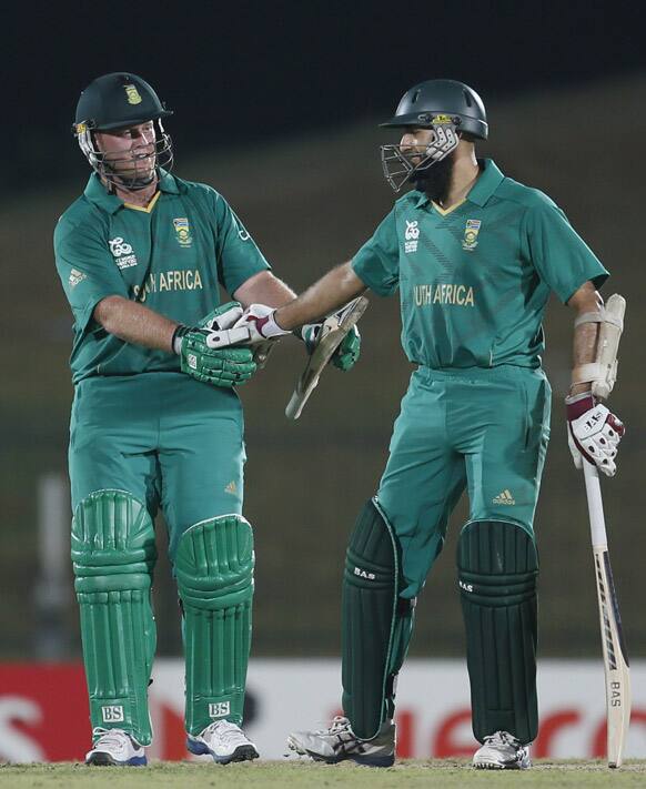 Hashim Amla, congratulates Richard Levi, as Levi completes a half-century during the ICC Twenty20 Cricket World Cup match.