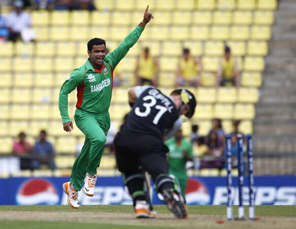 Bangladesh's bowler Abdur Razzak, left, celebrates after taking the wicket of New Zealand batsman Martin Guptill, right, during their ICC Twenty20 Cricket World Cup match in Pallekele, Sri Lanka.