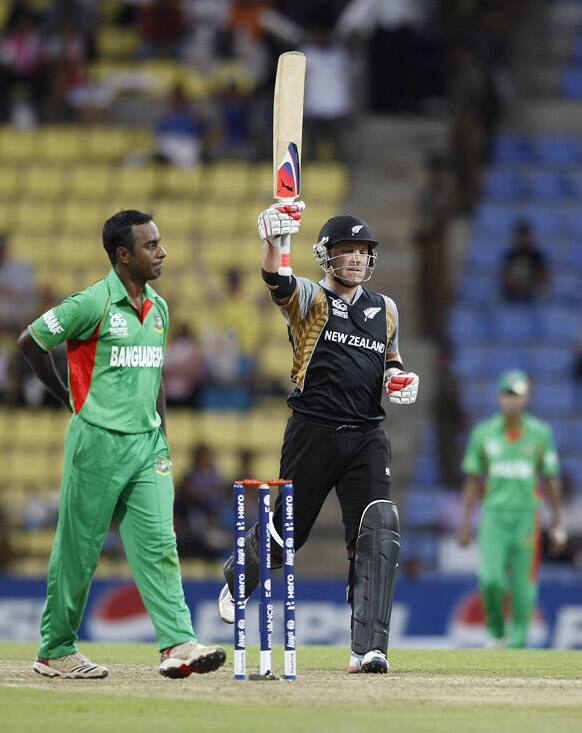 Bangladesh's bowler Elias Sunny watches as New Zealand batsman Brendon McCullum raises his bat to celebrate scoring a century during the ICC Twenty20 Cricket World Cup match in Pallekele, Sri Lanka.