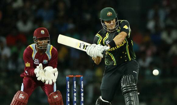 Australia's batsman Shane Watson, right, plays a shot as West Indies' wicket keeper Denesh Ramdin watches during their ICC Twenty20 Cricket World Cup match in Colombo.