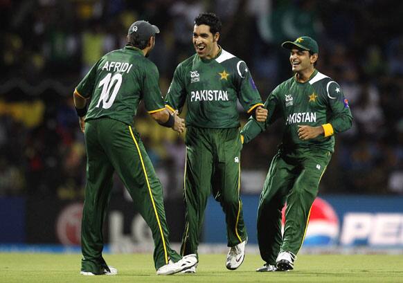 Pakistan's bowler Umar Gul, center, celebrates with teammate Shahid Afridi, left, and captain Mohammad Hafeez after taking the wicket of New Zealand's batsman Brendon McCullum, not seen, during their ICC Twenty20 Cricket World Cup match in Pallekele.