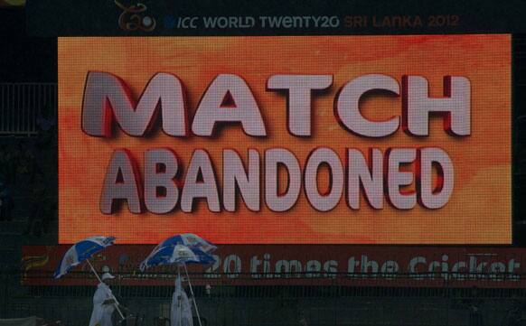 Ground staff walk past a giant screen as a ICC Twenty20 Cricket World Cup match between Ireland and West Indies is abandoned due to rain in Colombo.