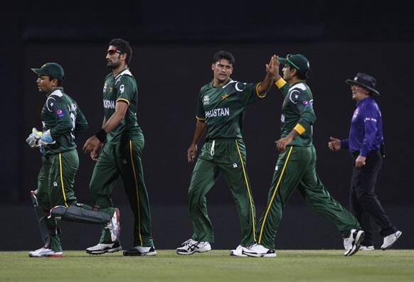 Pakistan's bowler Yasir Arafat, center, celebrates with teammates after taking the wicket of Bangladesh's captain Mushfiqur Rahim, during the ICC Twenty20 Cricket World Cup match in Pallekele.