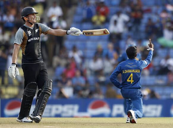 Sri Lanka's bowler Akila Dananjaya, right, raises his finger after taking the wicket of New Zealand's batsman Rob Nicol, left, during the ICC Twenty20 Cricket World Cup Super Eight match in Pallekele, Sri Lanka.