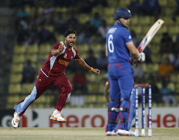 West Indies' bowler Ravi Rampaul, left, runs to celebrate after taking the wicket of England's batsman Luke Wright, right, during the ICC Twenty20 Cricket World Cup Super Eight match in Pallekele.