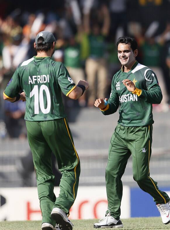 Pakistan's captain Mohammad Hafeez, right, celebrates the dismissal of South Africa's batsmen Jacques Kallis, unseen, with Shahid Afridi, left, during their ICC Twenty20 Cricket World Cup Super Eight match in Colombo.