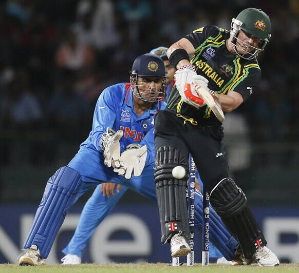 Australia's batsman David Warner, right bats as India's wicket keeper Mahendra Singh Dhoni watches during a ICC Twenty20 Cricket World Cup Super Eight match between India and Australia in Colombo.