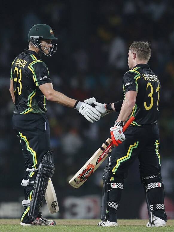 Australia's batsman Shane Watson, left, congratulates David Warner, right, as Warner reaches a half-century during a ICC Twenty20 Cricket World Cup Super Eight match between India and Australia in Colombo.