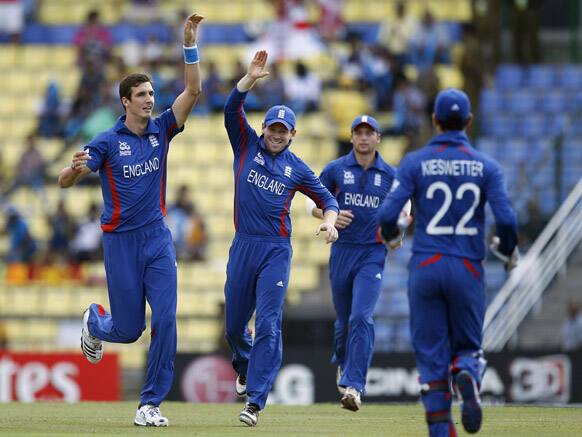 England's bowler Steven Finn, left, celebrates with teammates the dismissal of New Zealand's batsman Martin Guptill, not seen, during the ICC Twenty20 Cricket World Cup Super Eight match in Pallekele.