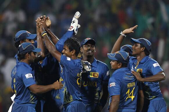 Nuwan Kulasekara celebrates the dismissal of West Indies' batsman Chris Gayle, with teammates during the ICC Twenty20 Cricket World Cup Super Eight match in Pallekele.