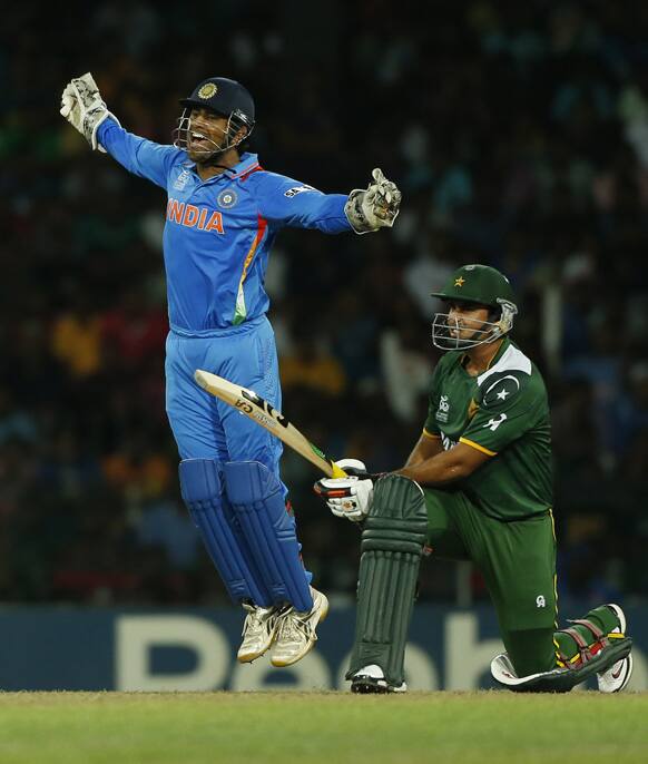 Mahendra Singh Dhoni, left, celebrates taking a catch to dismiss Pakistan's batsman Nasir Jamshed during the ICC Twenty20 Cricket World Cup Super Eight match between India and Pakistan in Colombo.