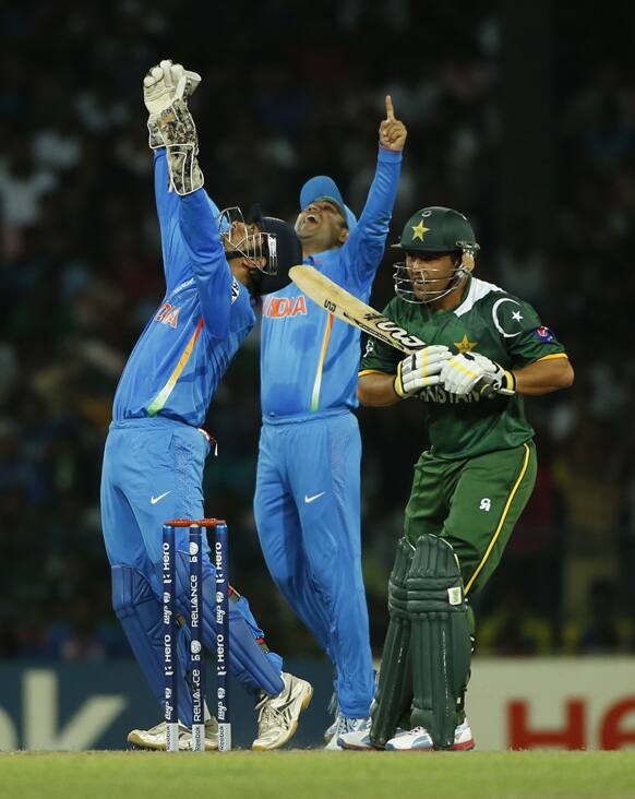 Mahendra Singh Dhoni, left, and fielder Virender Sehwag celebrate the dismissal of Pakistan's batsman Kamran Akmal during the ICC Twenty20 Cricket World Cup Super Eight match between India and Pakistan in Colombo.