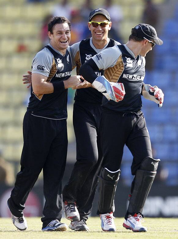 New Zealand's bowler Nathan McCullum, left, celebrates with captain Ross Taylor, center, the dismissal of West Indies' batsman Darren Bravo, not seen, during their ICC Twenty20 Cricket World Cup Super Eight match in Pallekele.