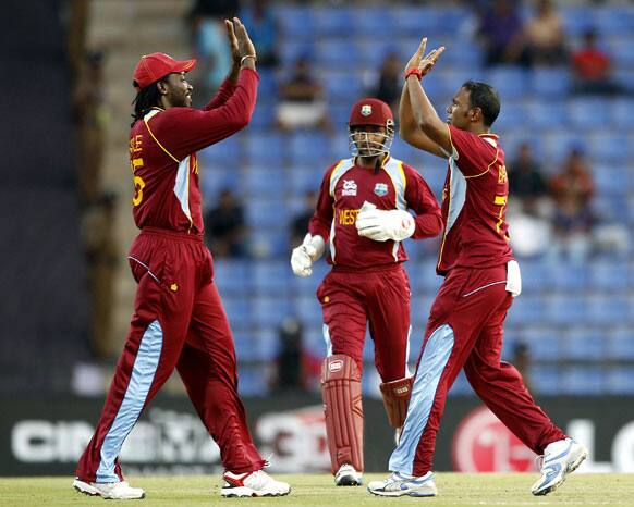 West Indies' bowler Samuel Badree, right, celebrates with teammate Chris Gayle, left, the dismissal of New Zealand's batsman Brendon McCullum, not seen, during the ICC Twenty20 Cricket World Cup Super Eight match in Pallekele.