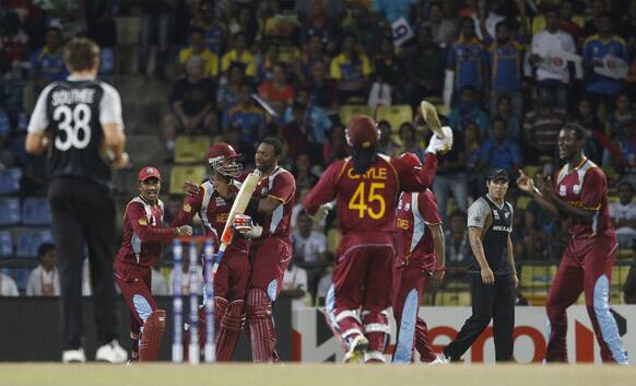 West Indies' players, center, celebrate their Super Over win over New Zealand in their ICC Twenty20 Cricket World Cup Super Eight match in Pallekele, Sri Lanka.