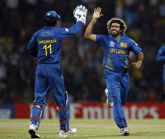 Sri Lanka's bowler Lasith Malinga, right, celebrates with teammate Kumar Sangakkara after taking the wicket of England's batsman Jos Buttler, not seen, during the ICC Twenty20 Cricket World Cup Super Eight match in Pallekele.