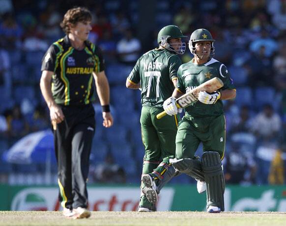 Australia's bowler Brad Hogg, left, watches Pakistan's batsmen Nasir Jamshed, center, and Kamran Akmal run between the wickets during their ICC Twenty20 Cricket World Cup Super Eight match in Colombo.